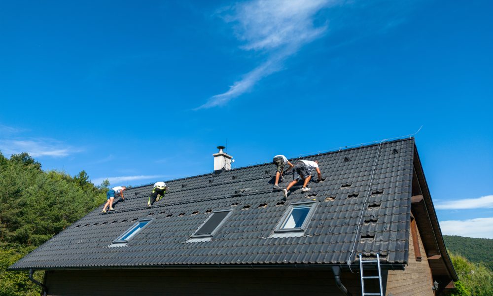 Men worker installing solar photovoltaic panels on a roof, alternative energy, saving resources and sustainable lifestyle concept.